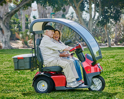 AFIKIM Red Afiscooter S3 Dual Seat Outdoor Mobility Scooter Side Angle With Rider On Terrain And Back Box View