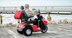 AFIKIM Red Afiscooter S3 Outdoor Mobility Scooter with Rider on Seaside, Side View