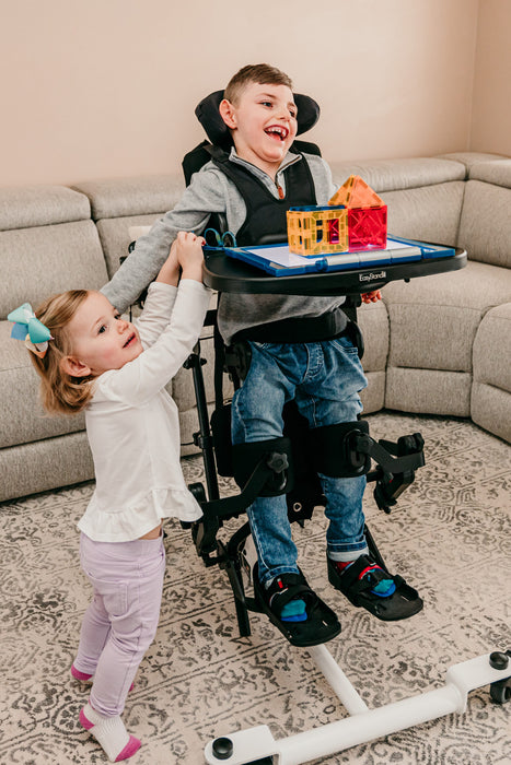 Altimate Medical EasyStand Bantam Small Stander With User Standing And Playing With Sister Social Activity