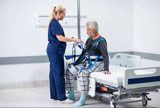 Arjo Walking Sling Loop Attachment Being Secured By Caregiver To Patient For Use
