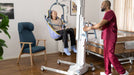 Arjo Maxi Move 5 Multifunctional Powered Patient Floor Lift With Patient And Caregiver In Bed To Chair View