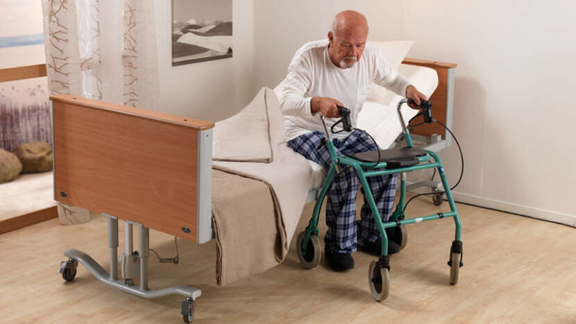 Arjo Minuet 2 Long Term Care Bed With Mattress Patient Getting Up From The Bed View