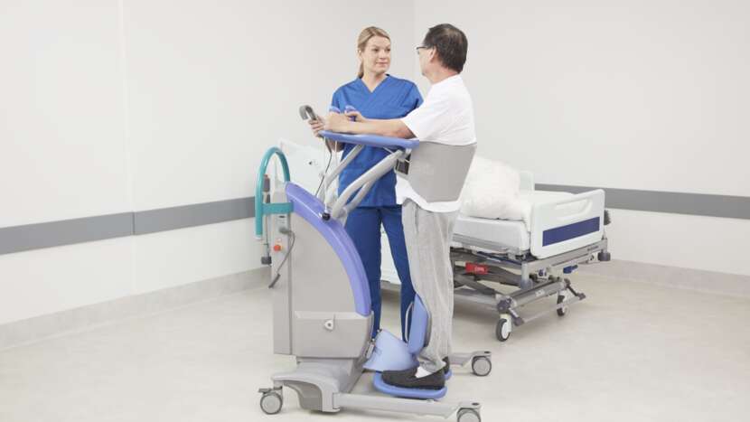 Arjo Sara Plus Sit to Stand With Patient And Caregiver Holding Hand Control View