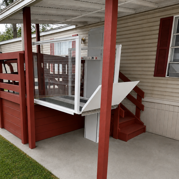 Atlas Nano Vertical Platform Lift Installed Outdoors At A Mobile Home Carport Deck Enclosed With Clear Glass Panels