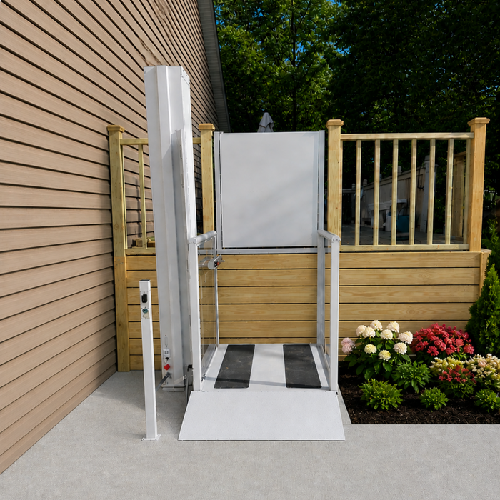 An Outdoor Residential Atlas Nano Vertical Platform Lift Installed Next To A Porch Wood Deck Alignment With A Concrete Landing Pad.