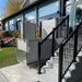 Atlas VISTA Vertical Platform Lift Installed Beside A Residential Exterior Wall.