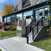Atlas VISTA Vertical Platform Lift Providing Accessible Entry Onto A Raised Wooden Porch Deck.