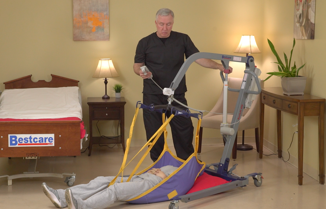 Bestcare BestLift ProCare PL400 Ergonomic Patient Lift With Caregiver Using Hand Control Lifting Patient From The Floor