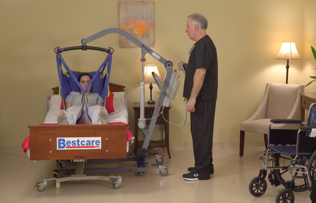 BestLift ProCare PL500 Ergonomic Patient Lift With Caregiver Holding Hand Control And Patient Transferred To Bed
