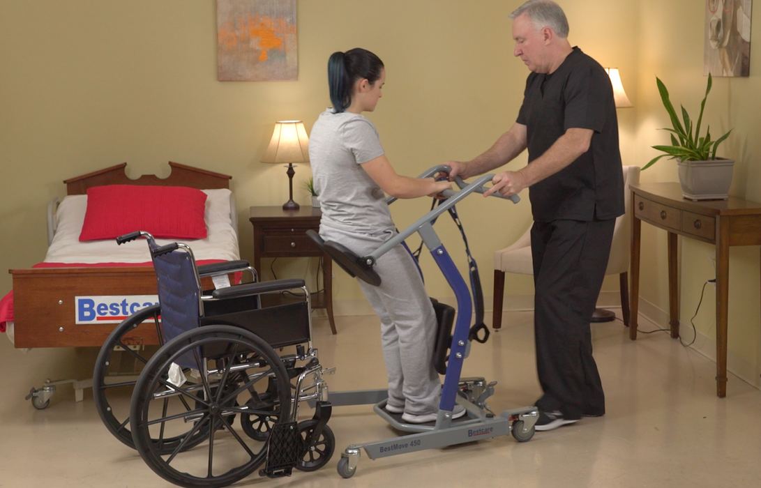 Bestcare BestMove STA450 Standing Transfer Aid With Caregiver And Patient Lifted In Wheelchair