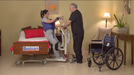 Bestcare BestStand SA400HE Mini Electric Sit-to-Stand Lift With Caregiver And Patient In Bedroom Transfer