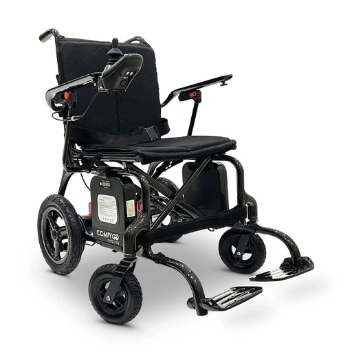 Black Standard ComfyGO Phoenix Carbon Fiber Electric Wheelchair Lightweight, Foldable, and Airline-Approved for Travel with battery pack is visibly attached under the seat and joystick controller mounted on the right armrest