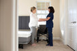 Flex A Bed Hi Low Adjustable Bed In Low Fully Flat Position With Mattress Pillow Headboard And User Holding Caregiver View