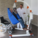 Handicare CARLO Alu Floor Lift With Anti-Rotation Mechanism For Safe Transfers And Fall Recovery Showing Wheelchair Transfer