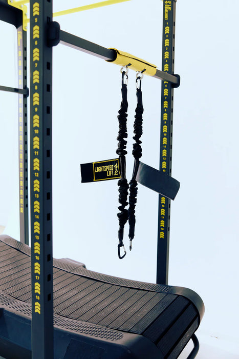 Lightspeed Lift LSX-500 body weight support system featuring black bungee cords and a padded attachment bar mounted over a curved manual treadmill for unweighted running and gait training.