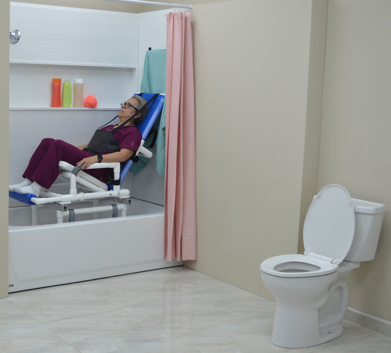 MJM International All Purpose Dual Shower Transfer Chair With Tilt Slider In Bathroom Setting With Patient In Reclined Head And Knee Raised Position Slide In Bathtub No Bridge View