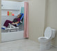 MJM International All Purpose Dual Shower Transfer Chair With Tilt Slider In Bathroom Setting With Patient In Reclined Head And Knee Raised Position Slide In Bathtub No Bridge View