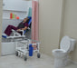 MJM International All Purpose Dual Shower Transfer Chair With Tilt Slider In Bathroom Setting With Patient In Reclined Head And Knee Raised Position Slide In Bathtub View