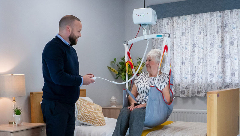 Mackworth CP440P Portable Ceiling Lift With Patient Being Lifted From Bed View