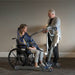 Proactive Medical Protekt® All-In-One Folding Electric Patient Lift With Patient And Caregiver In Wheelchair Transfer View