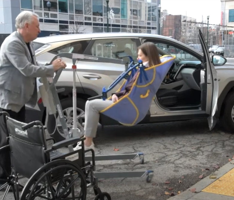 Proactive Medical Protekt® All-In-One Folding Electric Patient Lift With Patient And Caregiver In Car Transfer View