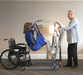 Proactive Medical Protekt® Take-A-Long Folding Electric Patient Lift With Patient And Caregiver In Wheelchair Transfer View