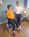 RizeUp Raizer II battery-operated lifting chair with carer assistance and seated user for emergency lift recovery.