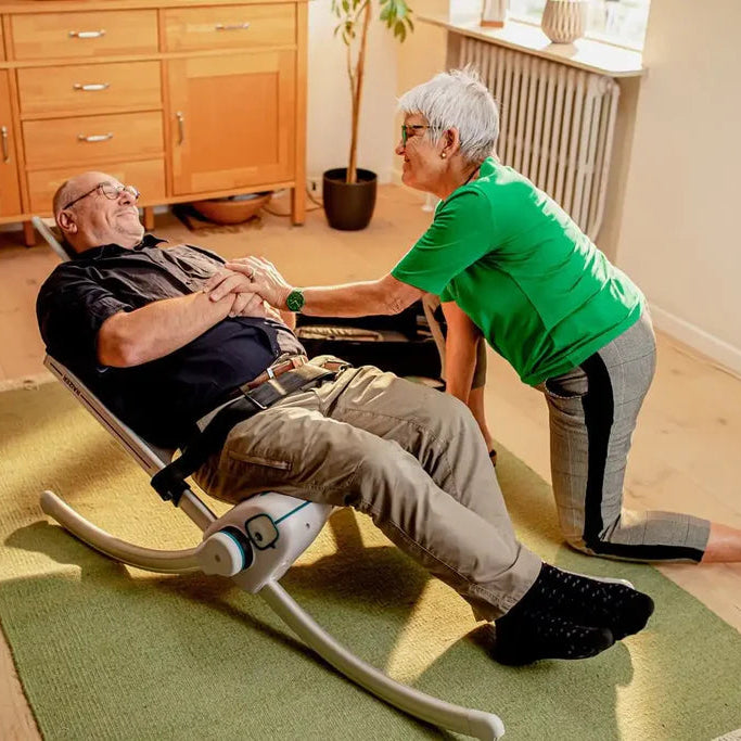 RizeUp Raizer M lifting chair with headrest in use by a carer to safely recover a patient from the floor.