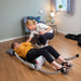 RizeUp Raizer II battery-operated lifting chair in action with a user being lifted from the floor and carer assistance.