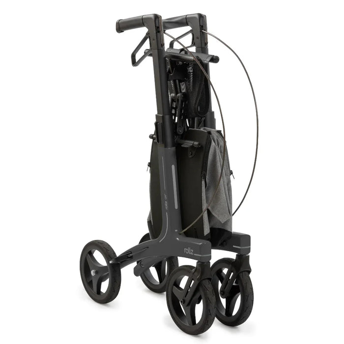 Rollz Air Carbon Rollator In Coal Black Folded Completely and Standing In An Upright Position.