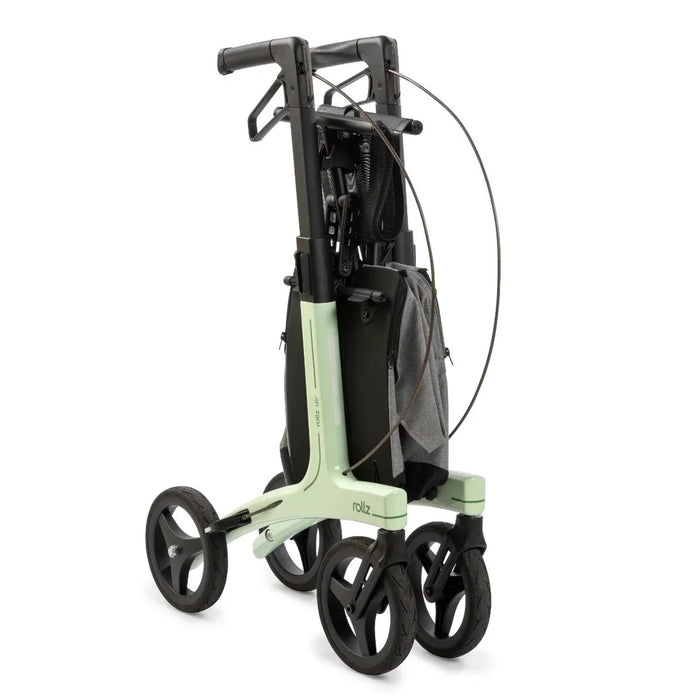 Rollz Air Carbon Rollator In Mint Green Folded Completely and Standing In An Upright Position.