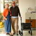 Rollz Air Carbon Rollator In Mint Green Being Easily Carried And Lifted By A User Indoors.