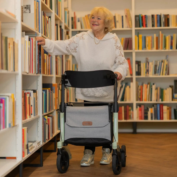 Rollz Air Carbon Rollator In Mint Green Being Navigated By A User Indoors.
