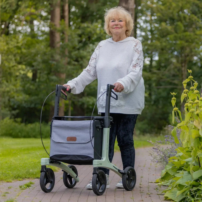 Rollz Air Carbon Rollator In Mint Green Being Used By A Person Walking.