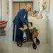 Rollz Flow Aluminum Walker In Granite Black Being Used Indoors To Store And Transport Groceries.