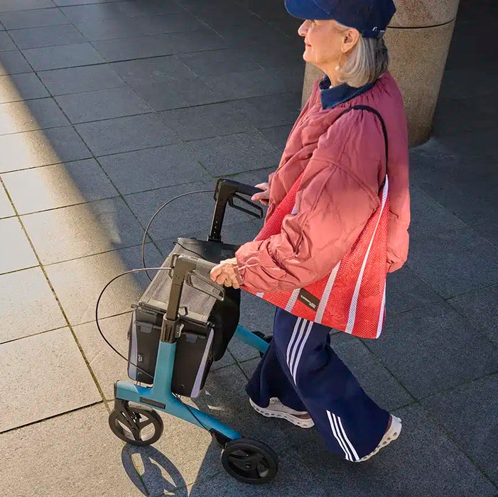 Rollz Flow Aluminum Walker In Granite Black Top Down View Of A User Walking Behind The Device.