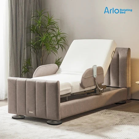 An electric adjustable rotating Starleep Orin bed with a beige tufted frame and white mattress, shown in a styled bedroom setting with a plant and curtains. The Arlo Rotating Bed logo is visible in the top right corner.