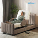 A woman in a green pajama set reclines on a Starsleep Orin Arlo ergonomic rotating chair bed with a padded headrest, side rails, and upholstered base, shown in a softly lit bedroom. The Arlo Rotating Bed logo appears in the top right corner.
